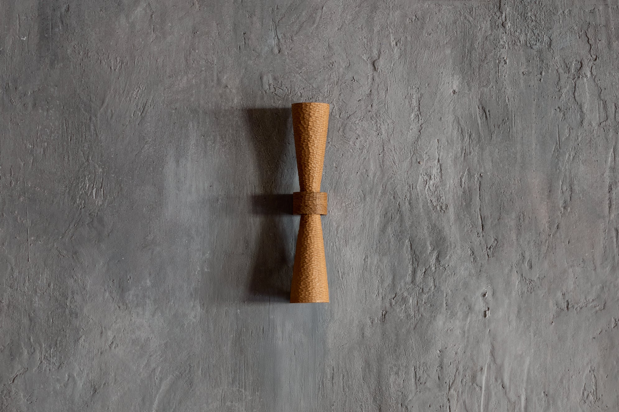 Sconce with a tiny scallop-textured and tapered upper and lower standoff allowing the texture to graduate from full light at the centre to diminished light at the ends really allowing the texture to come alive. It is just as beautiful in an entirely different way when not lit giving the sconce a whole new complexion.