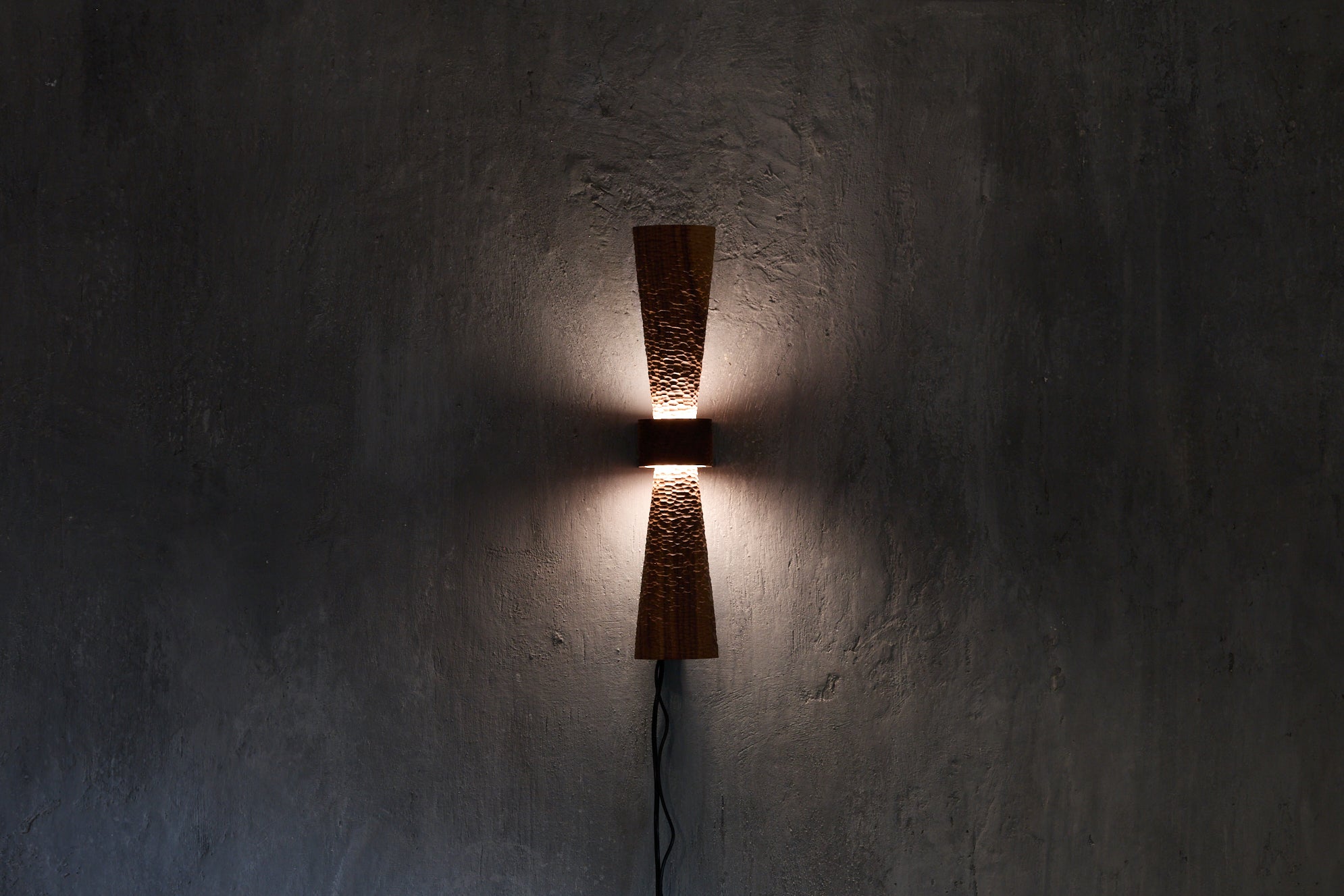 Sconce with a tiny scallop-textured and tapered upper and lower standoff allowing the texture to graduate from full light at the centre to diminished light at the ends really allowing the texture to come alive. It is just as beautiful in an entirely different way when not lit giving the sconce a whole new complexion.